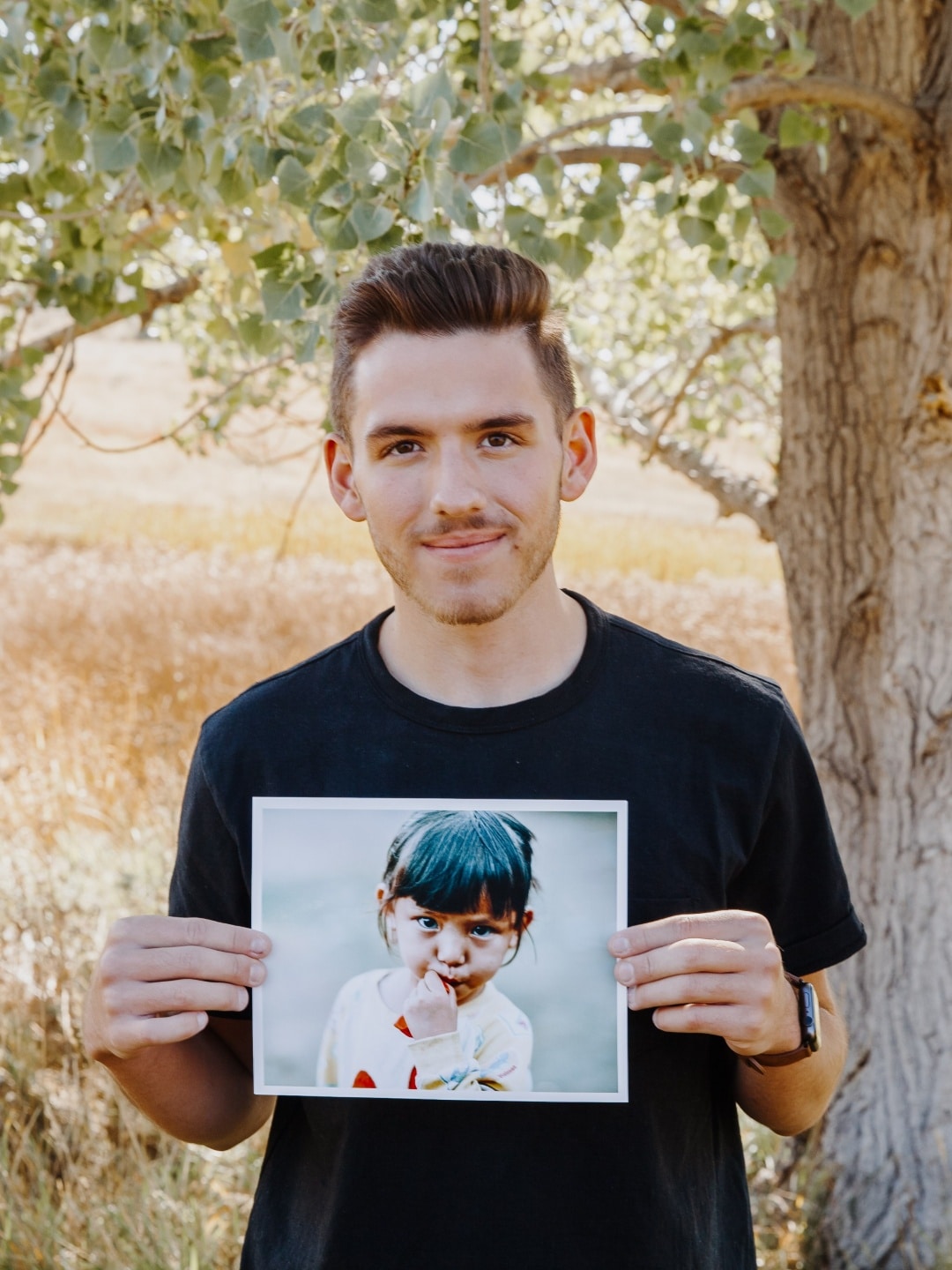 A man holding a picture of a young girl